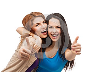 Two smiling girls showing thumbs up