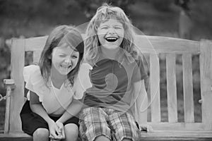 Two smiling laughing kids relaxing outdoors at summer park. Brother and sister happy walking in nature. Siblings boy and