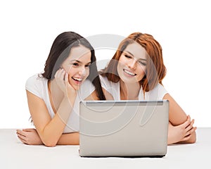 Two smiling teenage girls with laptop computer