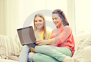 Two smiling teenage girls with laptop at home