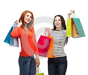 Two smiling teenage girls with shopping bags