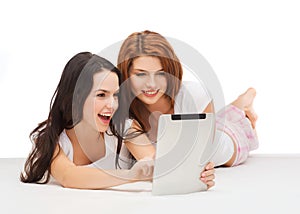 Two smiling teenage girls with tablet pc computer