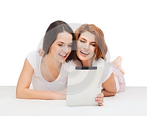 Two smiling teenage girsl with tablet pc computer