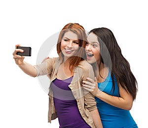 Two smiling teenagers with smartphone