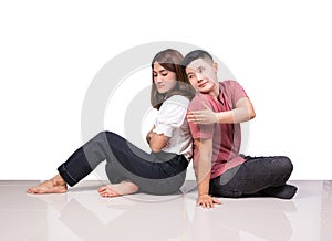 Two smiling woman young girls and happiness tomboy friends sitting on tile floor with white background