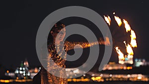 Two smiling women giving a fire show performance on the beach at late evening