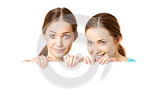 Two smiling women holding white blank poster