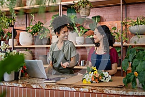 Two smiling women working at florist shop