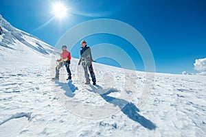 Two smiling young women Rope team descending Mont blanc du Tacul summit 4248m dressed mountaineering clothes with ice axes