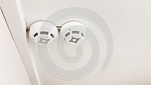 Two smoke detectors are installed on the ceiling in a residential building photo