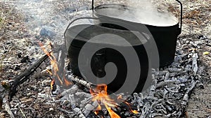 Two smoking cauldrons with hot watet on charcoal in summer