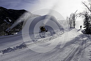 Two snow cannons are producing arteficial snow