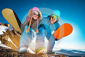 Two snowboarders male and female having fun and posing