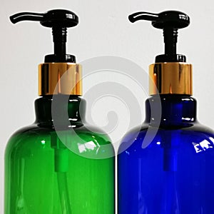 Two soap dispensers, one green and one blue.