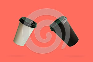 Two soaring paper cups of coffee on the coral background.Black and white - dual colors.Concept of coffee take away.Paper eco-