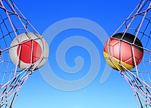 Two soccer balls in flags Japan and Germany