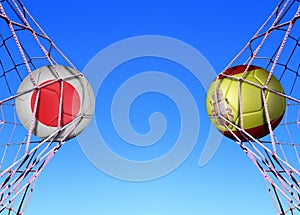 Two soccer balls in flags Japan and Spain