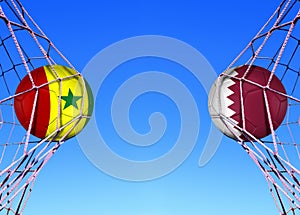 Two soccer balls in flags senegal and Qatar