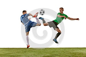 Two soccer players in action, motion on green grass flooring isolated over white background. Concept of global sport