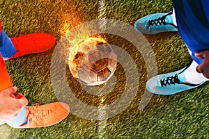 Two soccer players challenge each other at the stadium ready to kick a fiery ball
