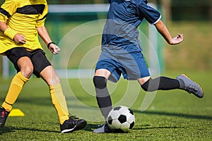 Two soccer players compete in a duel. Footballers kicking ball