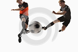 Two soccer players kicking a soccer ball