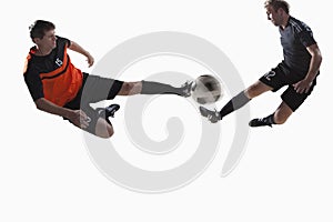 Two soccer players kicking a soccer ball