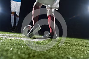 Two soccer players kicking a soccer ball