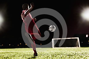 Two soccer players kicking a soccer ball at game