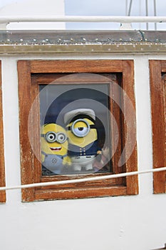 Two soft toys Mignons in the square porthole of the ship`s superstructure