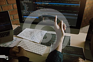 Two software developers are analyzing together about the code written into the program on the computer