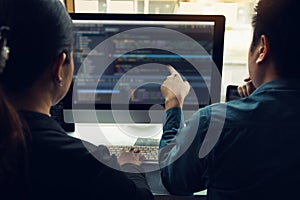 Two software developers are analyzing together about the code written into the program on the computer