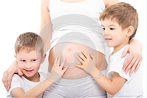 Two sons hugging belly pregnant mother