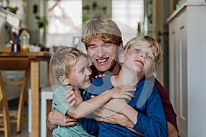 Two sons kissing father's cheeks. Concept of Father's Day, and fatherly love. Real family, real people.