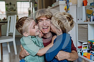 Two sons kissing father's cheeks. Concept of Father's Day, and fatherly love. Real family, real people.