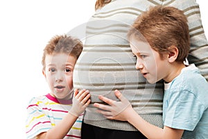 Two sons touching or bonding their pregnant mother abdomen