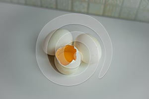 Two sound eggs and one cracked egg with yellow yolk
