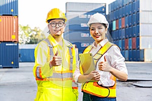 Two Southeast Asian engineers posing confidently in front of shipping containers.