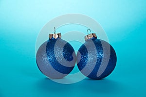 Two sparkling Christmas ball on light blue