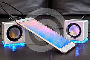 Two speakers with blue LEDs are connected to smartphone