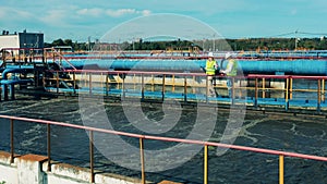 Two specialists examining a clarifier at a biological wastewater treatment facility. Water management concept.