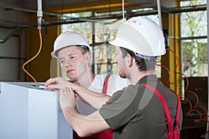 Two specialists repairing factory machine