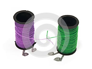 Two spools with threads with their endings tied together