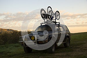 Two sports bicycles over jeep