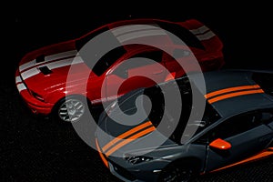 Two sports cars on a black background. Sports cars at night. Need for speed