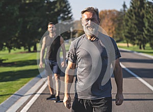 The two sportsmen standing on the road in the park.