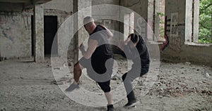 Two sportsmen training free fighting with skilled in an abandoned building