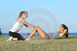 Two sportswomen doing crunches photo