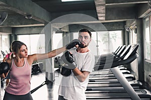 Two Sporty Couple are Training Boxing in Fitness Club, Young Woman is Knock-Out Punching to Her Boyfriend, Sport and Healthy