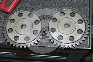 Two sprockets of the timing chain mechanism lie on a gray desktop